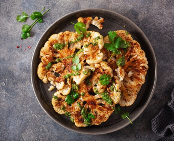 cauliflower steaks with herb sauce and spice. plant based meat substitute