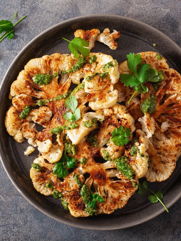 cauliflower steaks with herb sauce and spice. plant based meat substitute