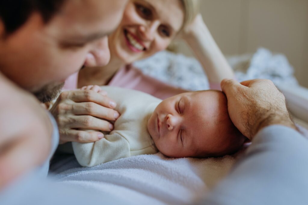 Close-up of parents cuddling their newborn baby.